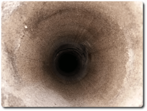 Close up of hole in sand left once 110mm pipe was removed