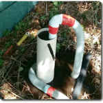 Photo of 50mm pipe inserted down 110mm pipe, with hose from pool pump