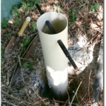 Short length of 110mm pipe still protruding from ground, with round steel bar inserted as a twisting handle