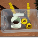Top view of the plastic box, with one 75mm hole, and two 20mm holes, with plastic fittings installed